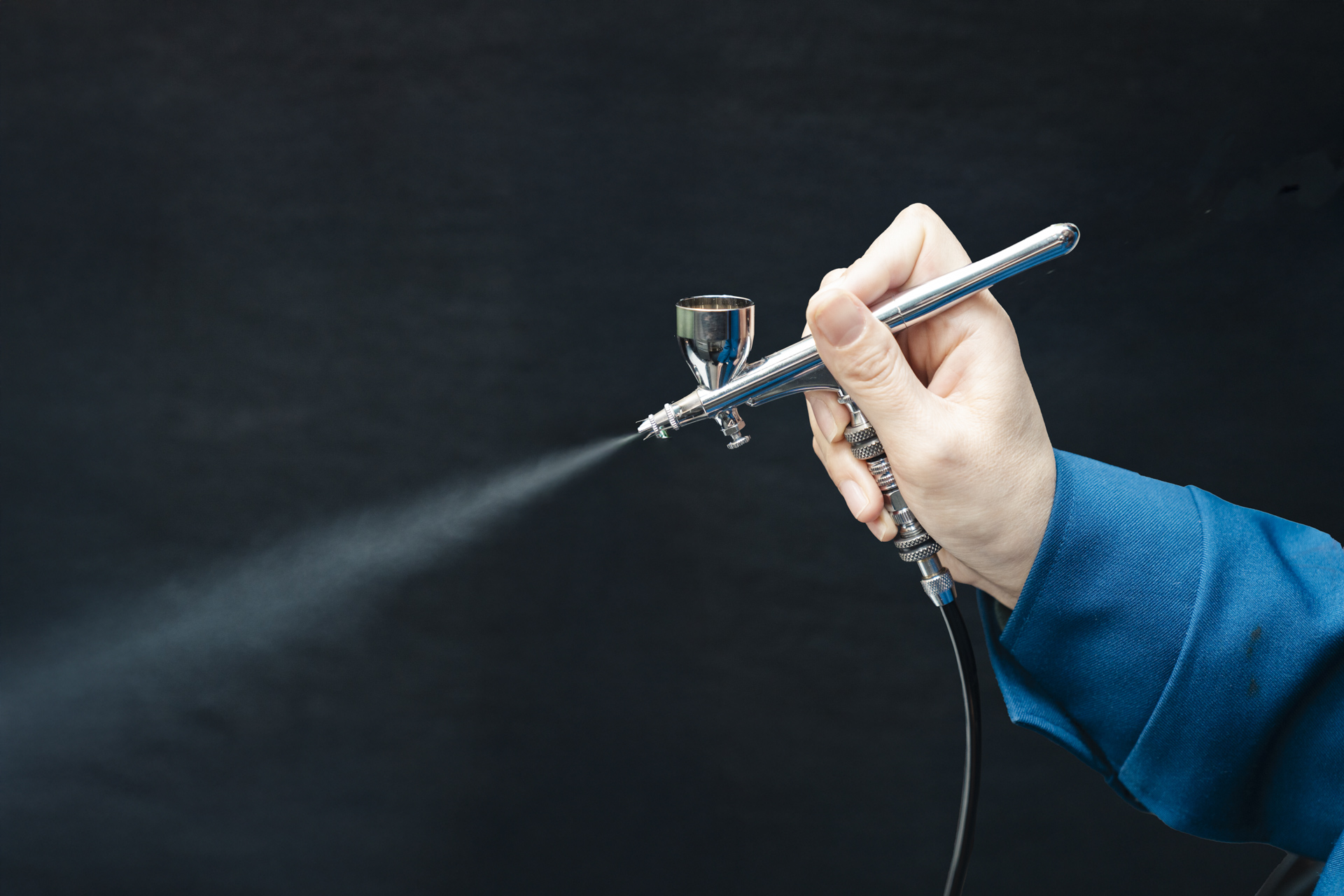 エアブラシで霧状の液体を噴射する様子